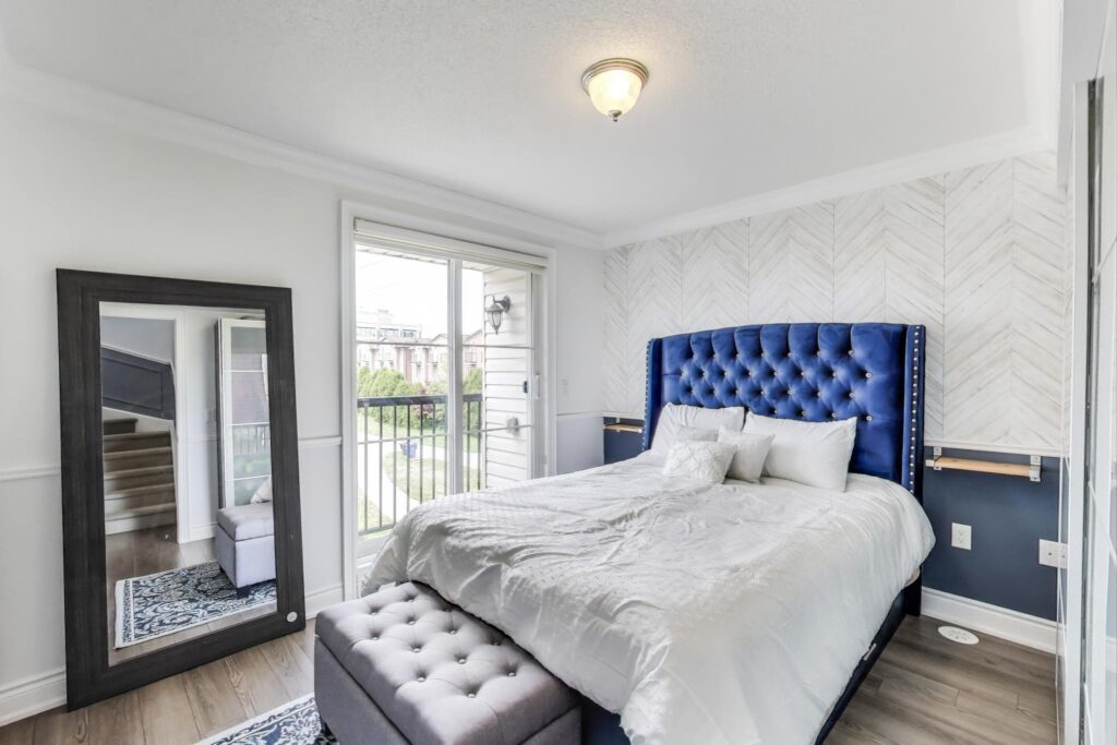 Primary bedroom at 380 Hopewell Ave #231 with large windows, full-sized furniture, and a private, quiet balcony overlooking the Toronto Beltline Trail.