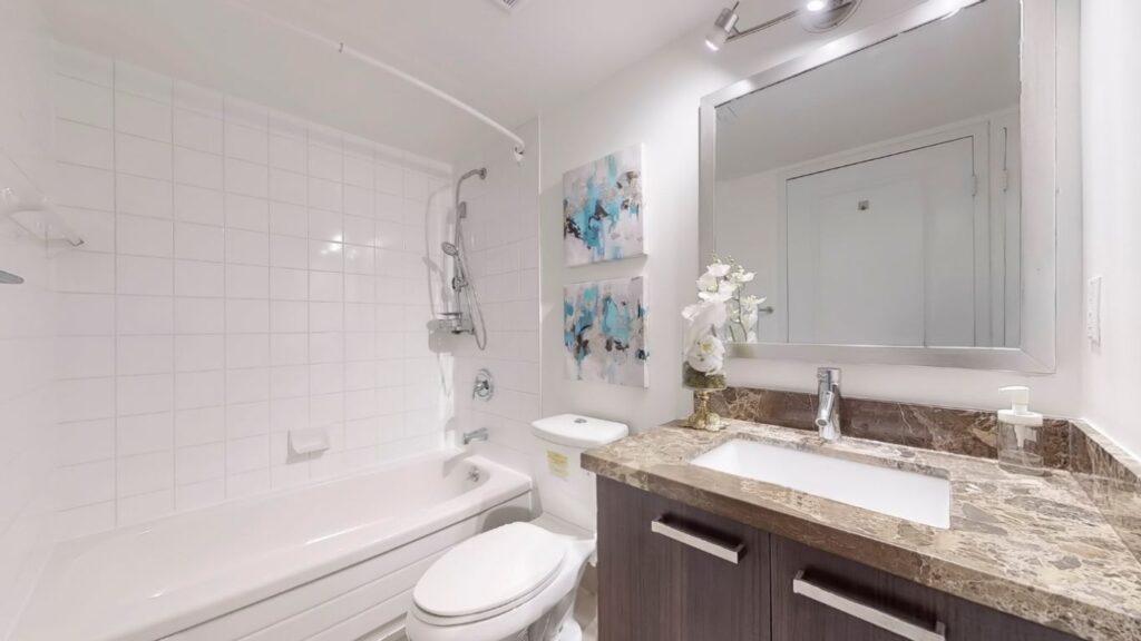 Updated washroom at 11 St Joseph St #402 showcasing modern fixtures, sleek tilework, and a clean, contemporary design.
