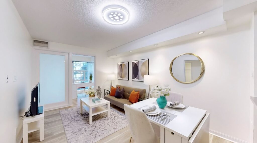 Living and dining area at 11 St Joseph St #402 with view toward the enclosed den featuring a sliding barn door, perfect for a home office or guest room.