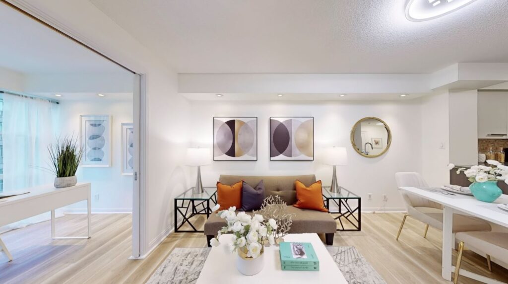 Straight-on view of the living room at 11 St Joseph St #402 showcasing bright, neutral flooring, open layout, and seamless flow into the kitchen.
