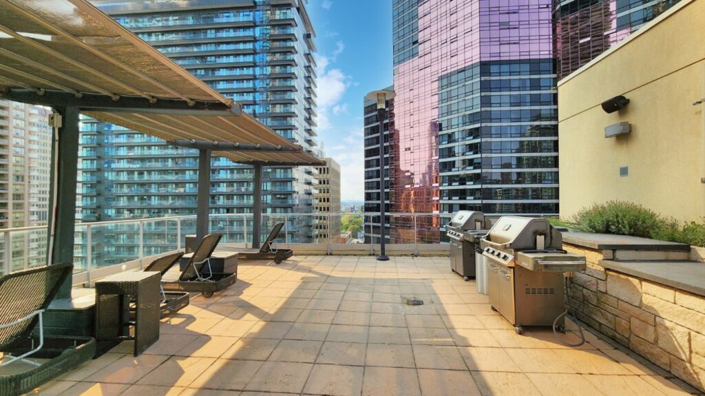 Rooftop BBQ area at Eleven Residences, 11 St Joseph St, equipped with gas grills and dining space for residents to cook and entertain outdoors.