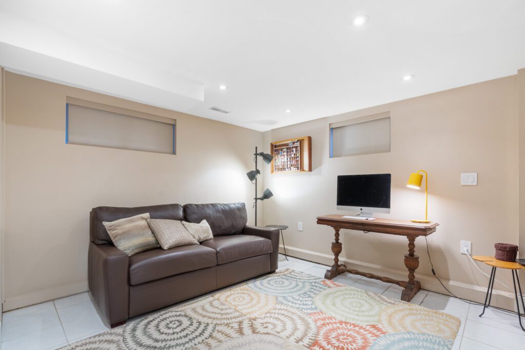 Basement rec room at 1370 Davenport Rd with sofa, soft lighting, and flexible space for movie nights, playroom, or home office setup.