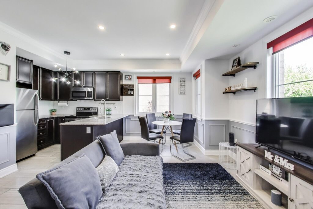 Open-concept main floor at 380 Hopewell Ave #231 featuring bright windows, custom wainscotting, hardwood floors, and a spacious living-dining layout with main floor powder room.