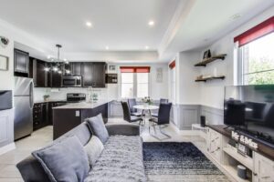 Open-concept main floor at 380 Hopewell Ave #231 featuring bright windows, custom wainscotting, hardwood floors, and a spacious living-dining layout with main floor powder room.