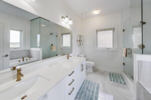 Primary ensuite at 59 Maskells Cres—double vanity with brass faucets, glass shower and soaker tub.