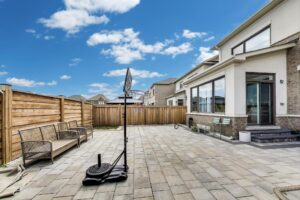 Low-maintenance backyard at 59 Maskells Cres with full interlock patio and privacy fence