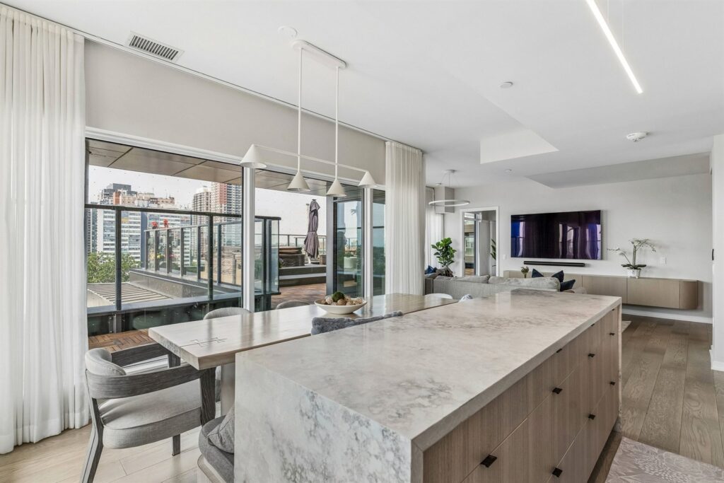 Modern kitchen with large island and city views at 10 Graphophone Grove #702, Toronto