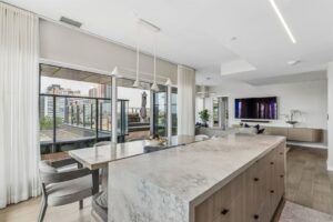 Modern kitchen with large island and city views at 10 Graphophone Grove #702, Toronto